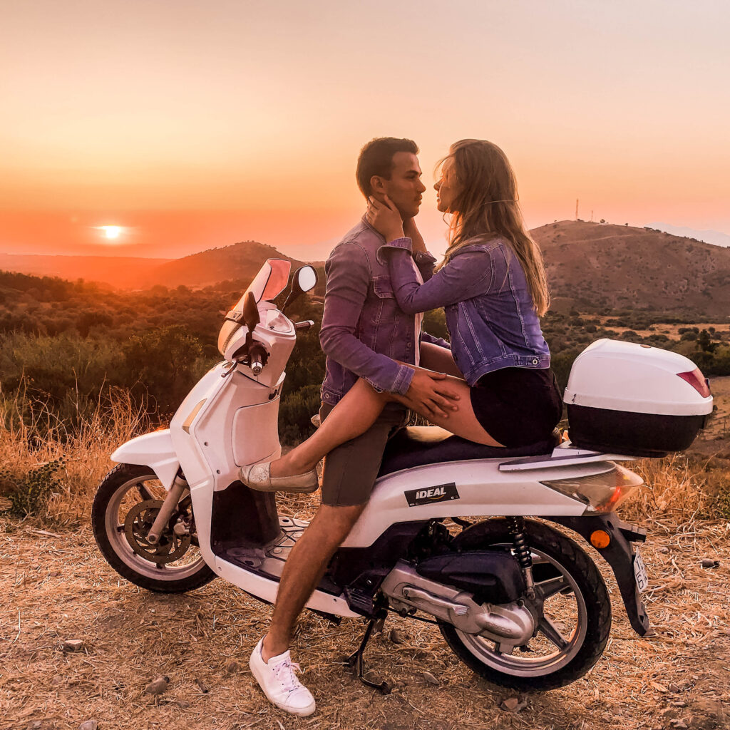 Couple sitting on a scooter at sunset on Kos