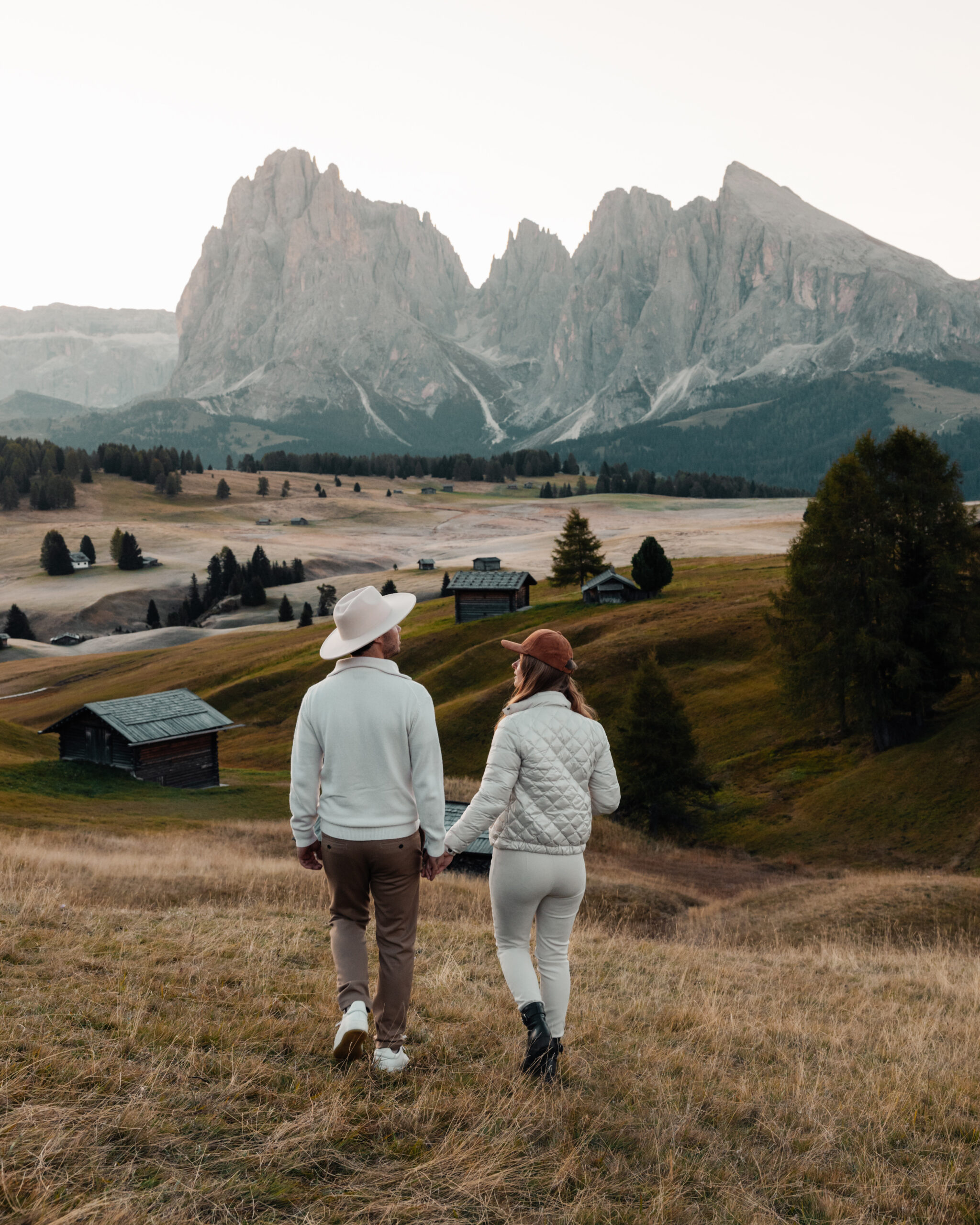 Lukas and Lore walk hand in hand in the meadow of Alpe di Siusi, Dolomites