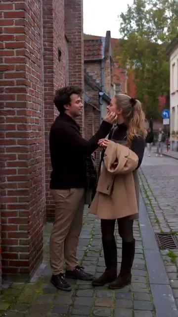 Couple in autumn coats in a brick alley in Bruges