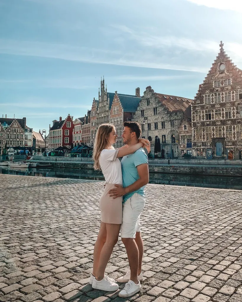 Couple on a Ghent quay with the old town skyline behind them