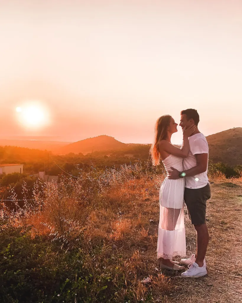 Couple watching the sun go down over the hills of Kos at sunset