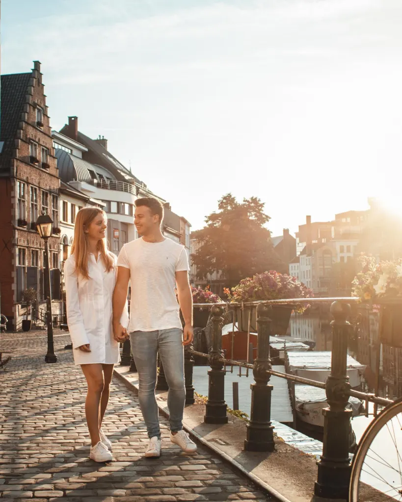 Couple walking through an empty Ghent street in warm sunrise light
