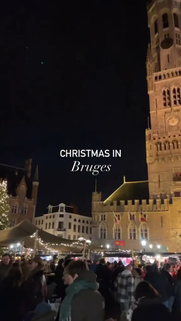 Bruges Markt square and belfry lit up at night during the Christmas market
