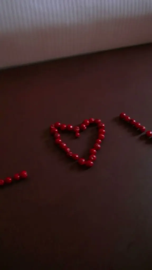 Heart made of red beads on a dark surface in a Brussels hotel room